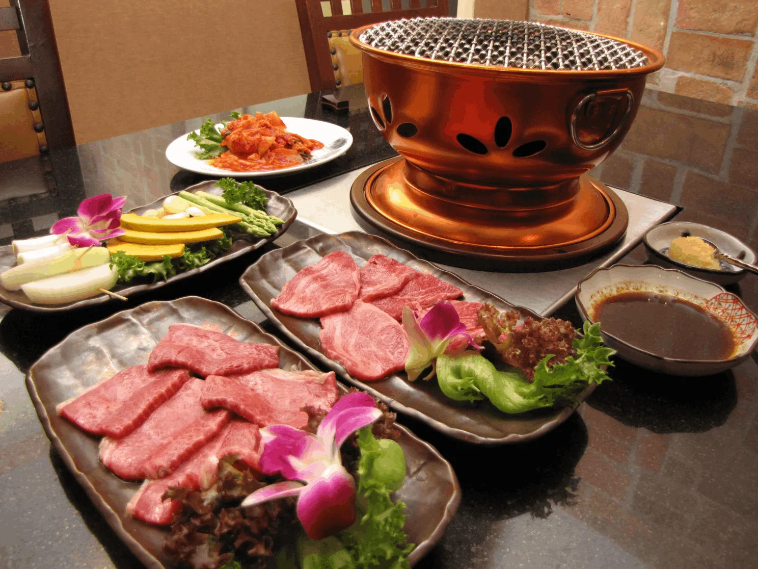 七輪と霜降り和牛を並べた焼肉のセット